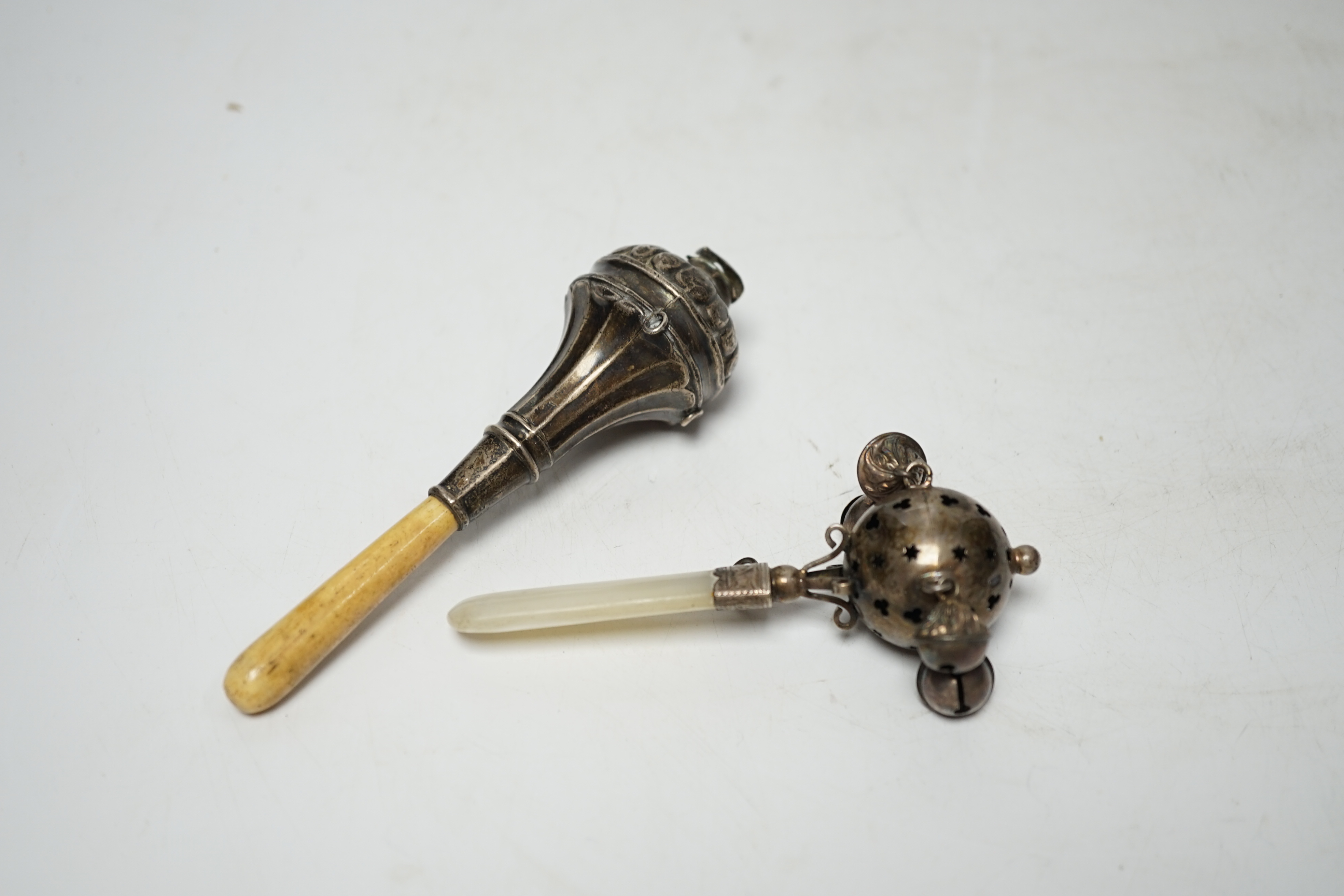 Two baby's silver rattles, Edwardian with mother of pearl handle, Birmingham, 1908, 10cm and later George V with bone handle and lacking bells.